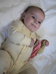 Cream ribbed footless sleepsuit with press studs from top to bottom