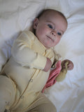 Cream ribbed footless sleepsuit with press studs from top to bottom